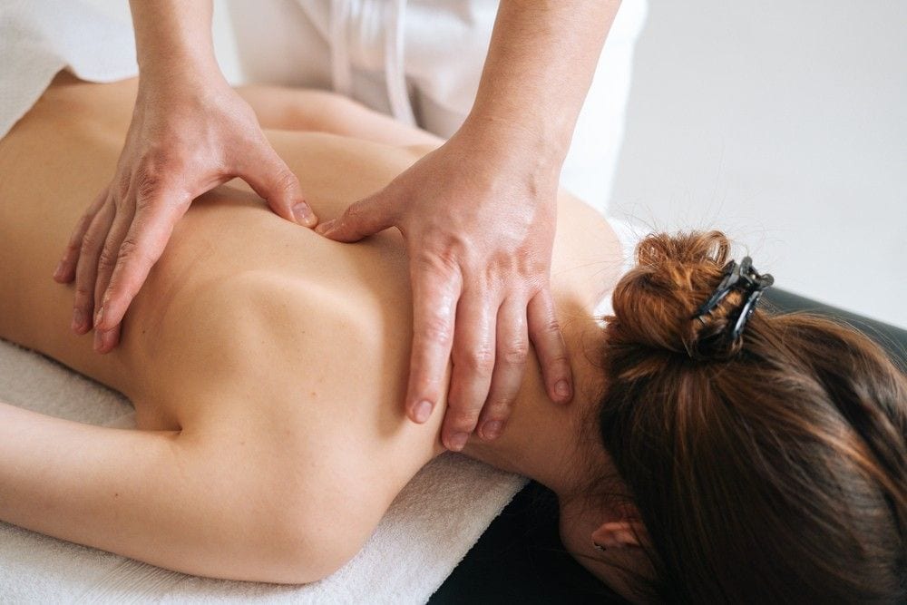 Profissional realizando massagem nos ombros e nas costas de uma cliente